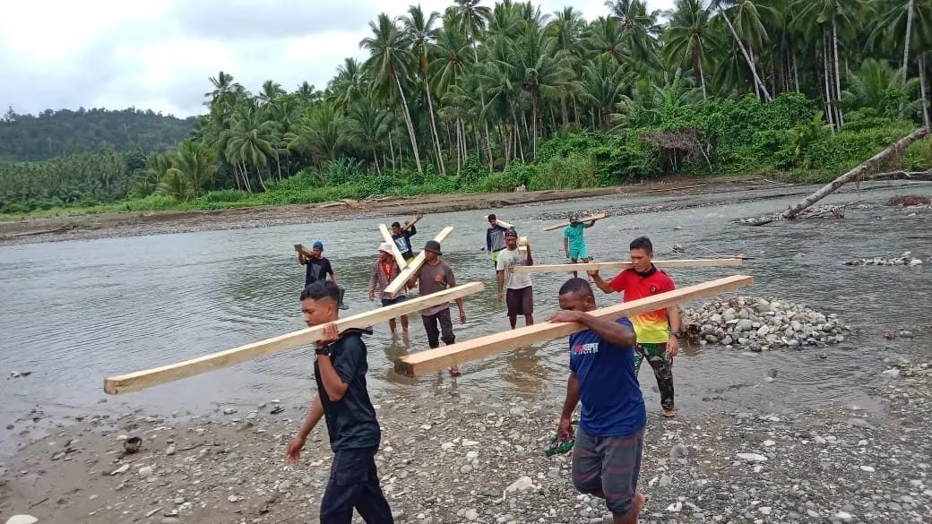 Sebrangi Sungai, Anggota Satgas TMMD Bersama Warga Pikul Kayu