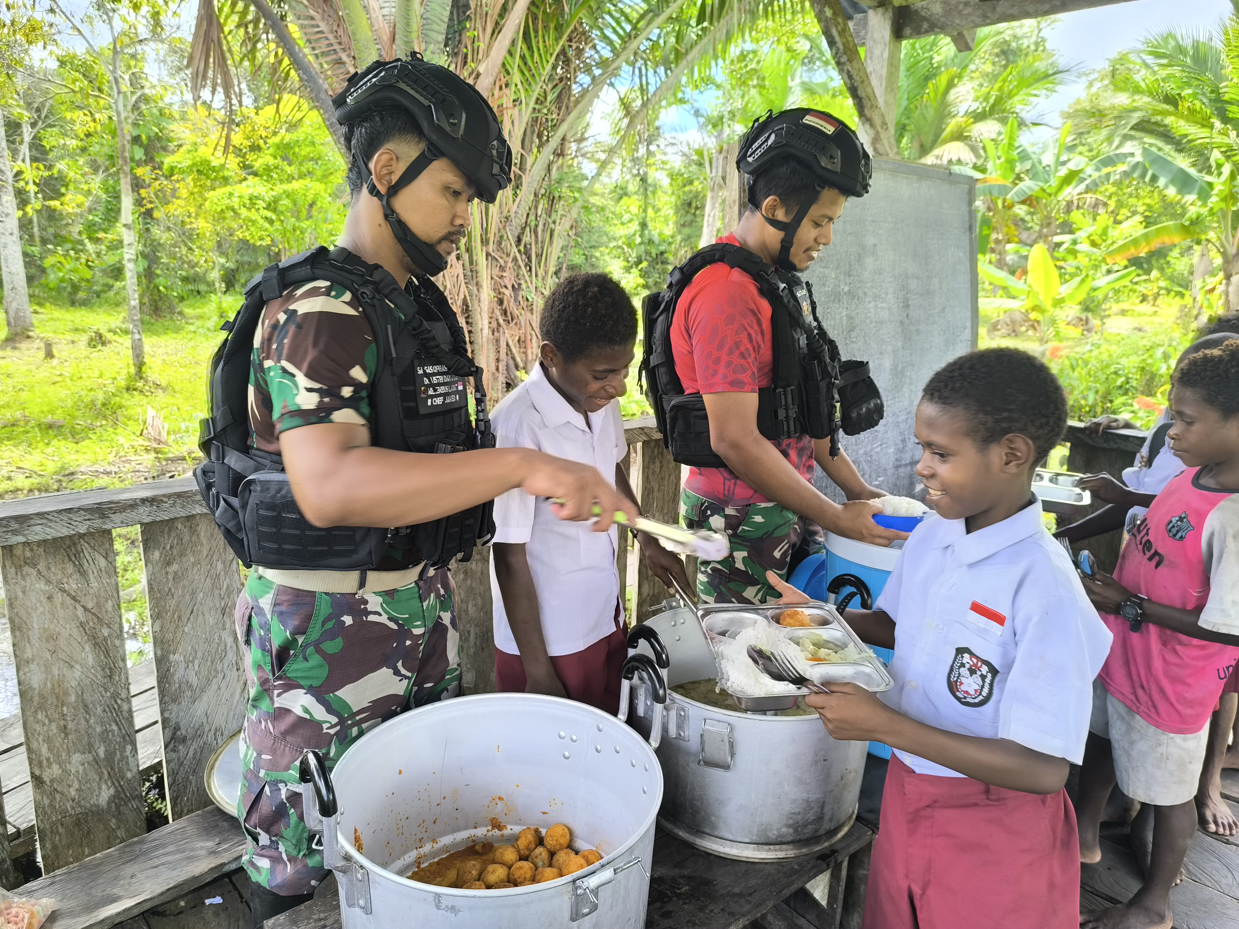 Satgas Yonif 733/Masariku Berbagi Kasih Dengan Membagikan Makanan Bergizi di SD Rimba Mamugu