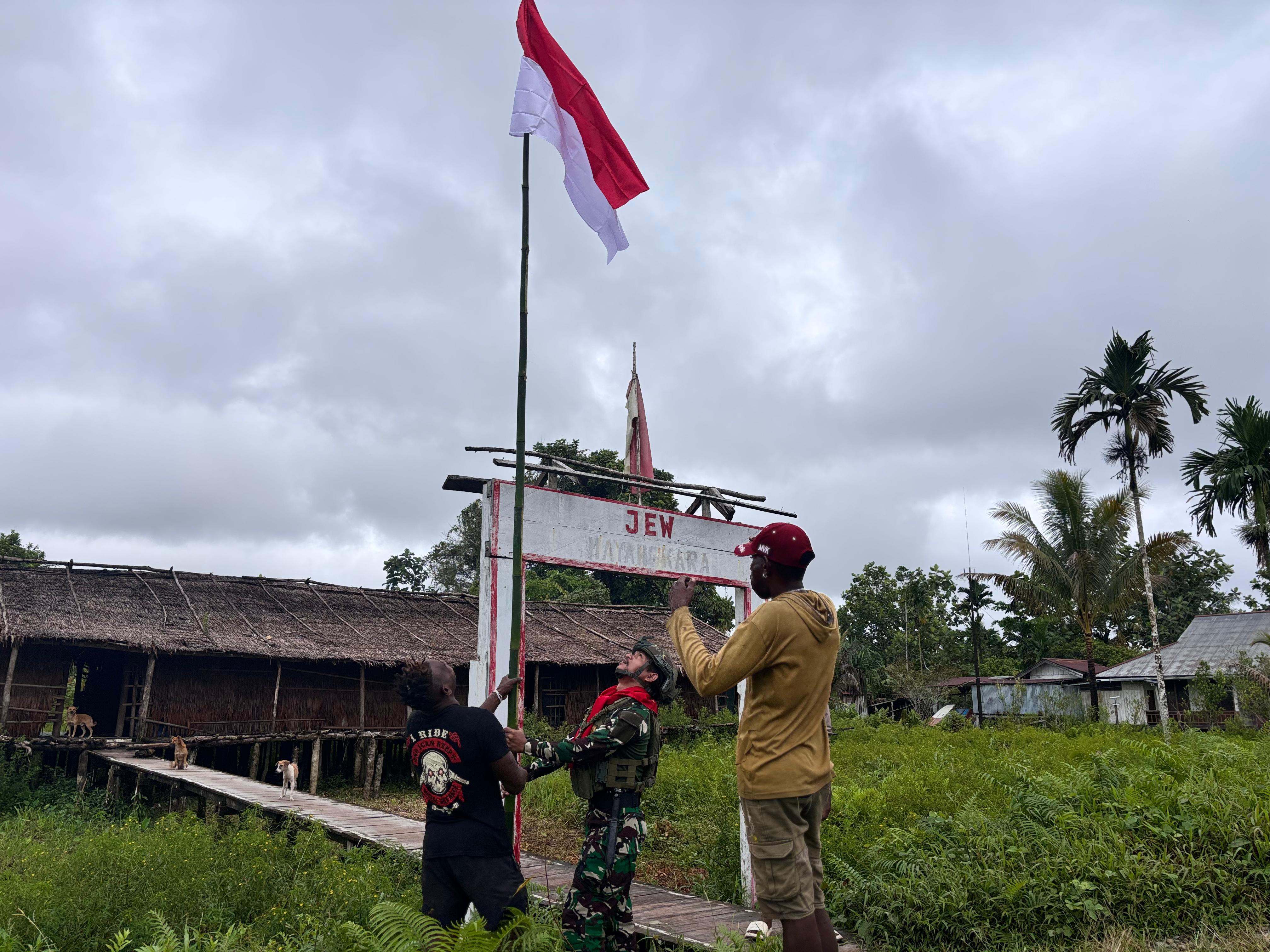 Semangat Gotong Royong Prajurit Satgas Pamtas Mobile Yonif 733/Masariku dengan Warga Mumugu Mengibarkan Bendera Merah Putih Sambut HUT RI ke-80