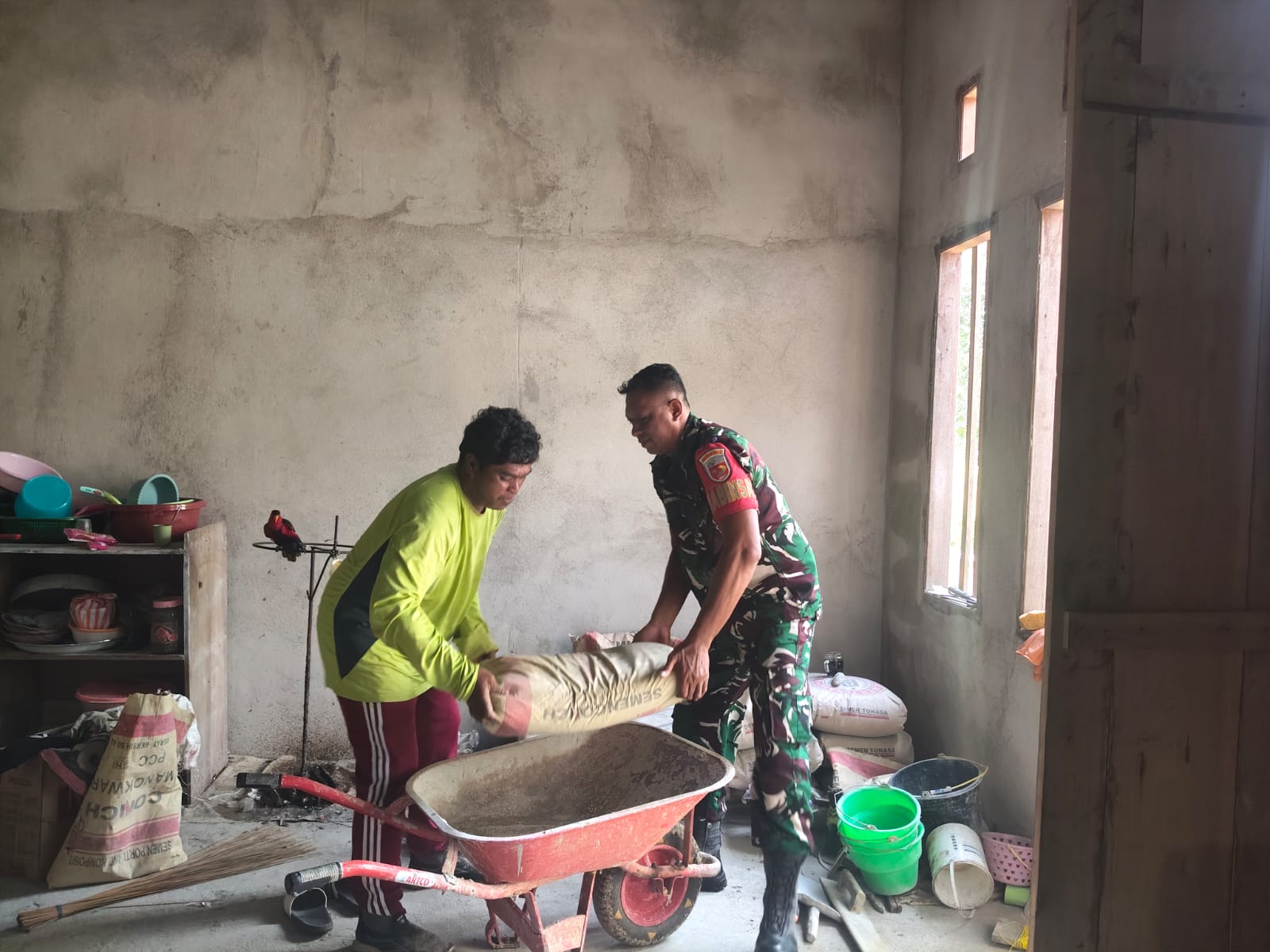 Selalu Peduli Babinsa Desa Umiyal Koramil 1512-03/Gebe Bantu Campur Semen dan Pasir Untuk Plester Dinding Rumah Warga di Wilayah Binaan