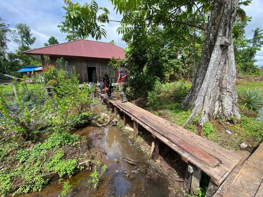 PRAJURIT SATGAS PAMTAS MOBILE YONIF 733/MASARIKU GOTONG ROYONG PERBAIKI JEMBATAN SD RIMBA MUMUGU