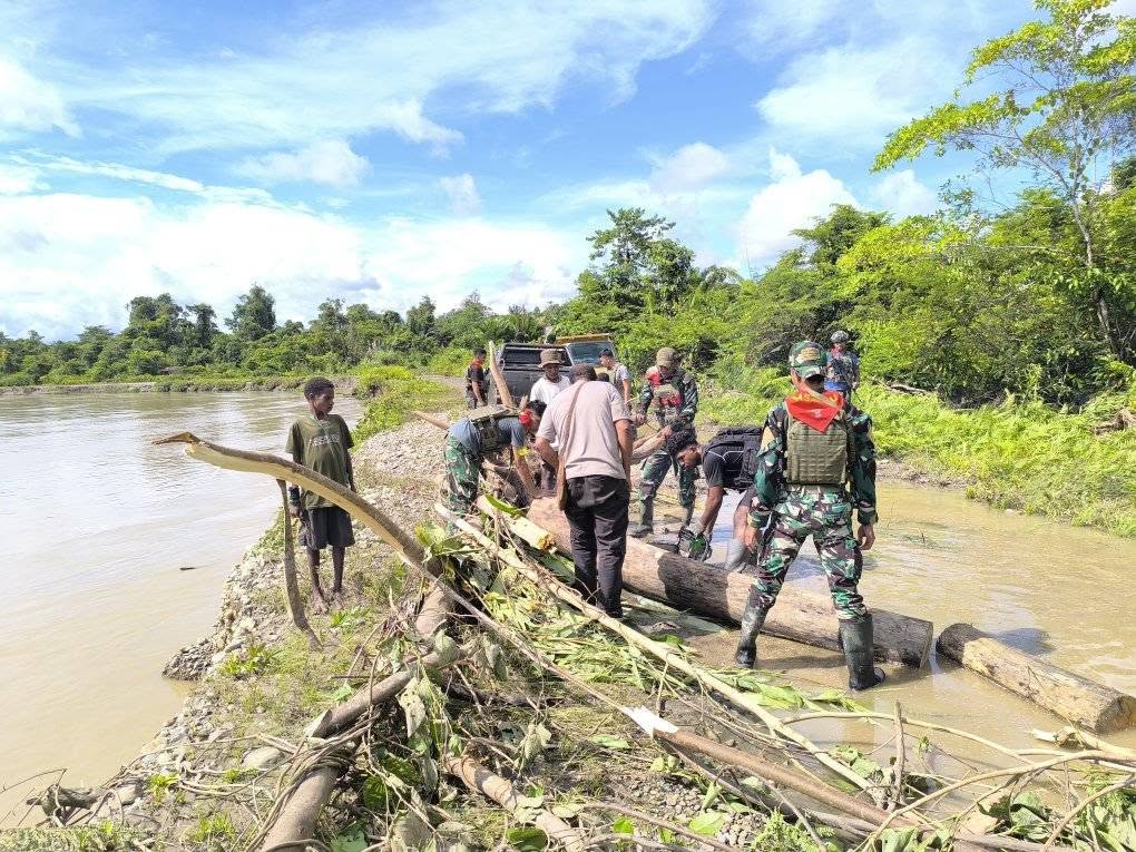PRAJURIT SATGAS YONIF 733/MASARIKU BANTU MASYARAKAT BERSIHKAN POHON TUMBANG