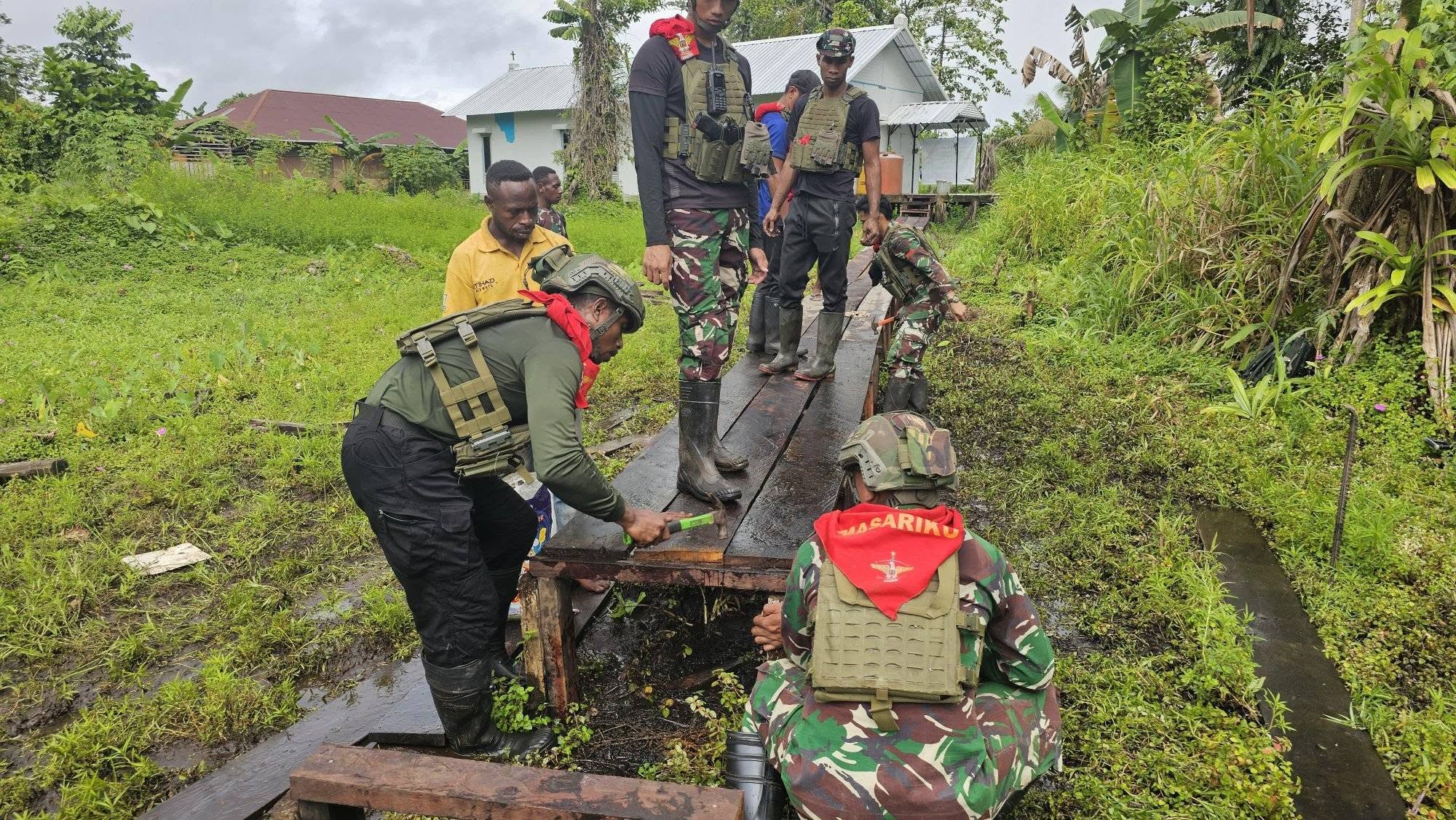 PRAJURIT SATGAS PAMTAS MOBILE YONIF 733/MASARIKU LAKSANAKAN PERBAIKAN JEMBATAN DI SEKOLAH DASAR RIMBA MUMUGU