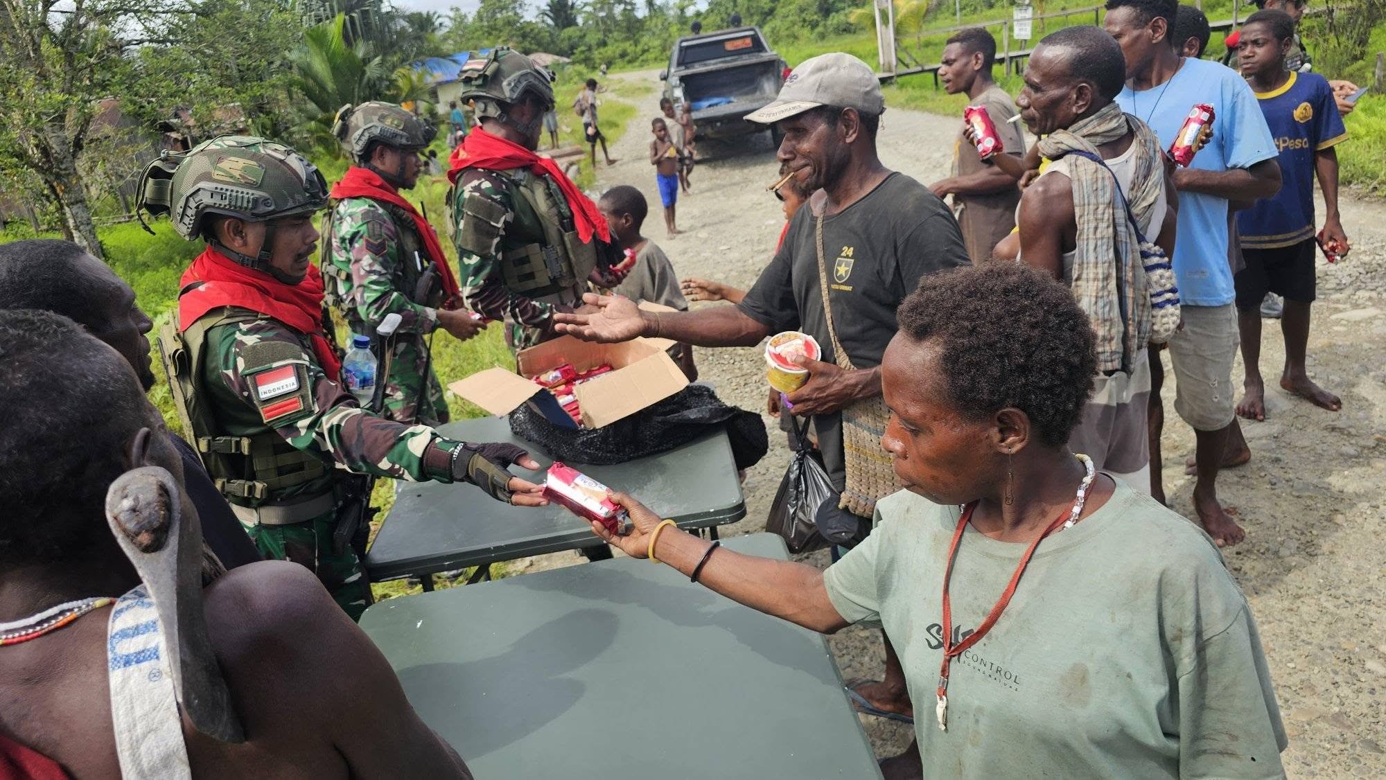 TEBARKAN KEBAHAGIAAN MELALUI PEMBAGIAN PAKAIAN DAN MAKANAN : PRAJURIT SATGAS PAMTAS MOBILE YONIF 733/MASARIKU MEMBAGIKAN PAKAIAN LAYAK PAKAI DAN BISKUIT KEPADA MASYARAKAT DISTRIK KREPKURI
